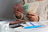 Close up person counting Canadian money